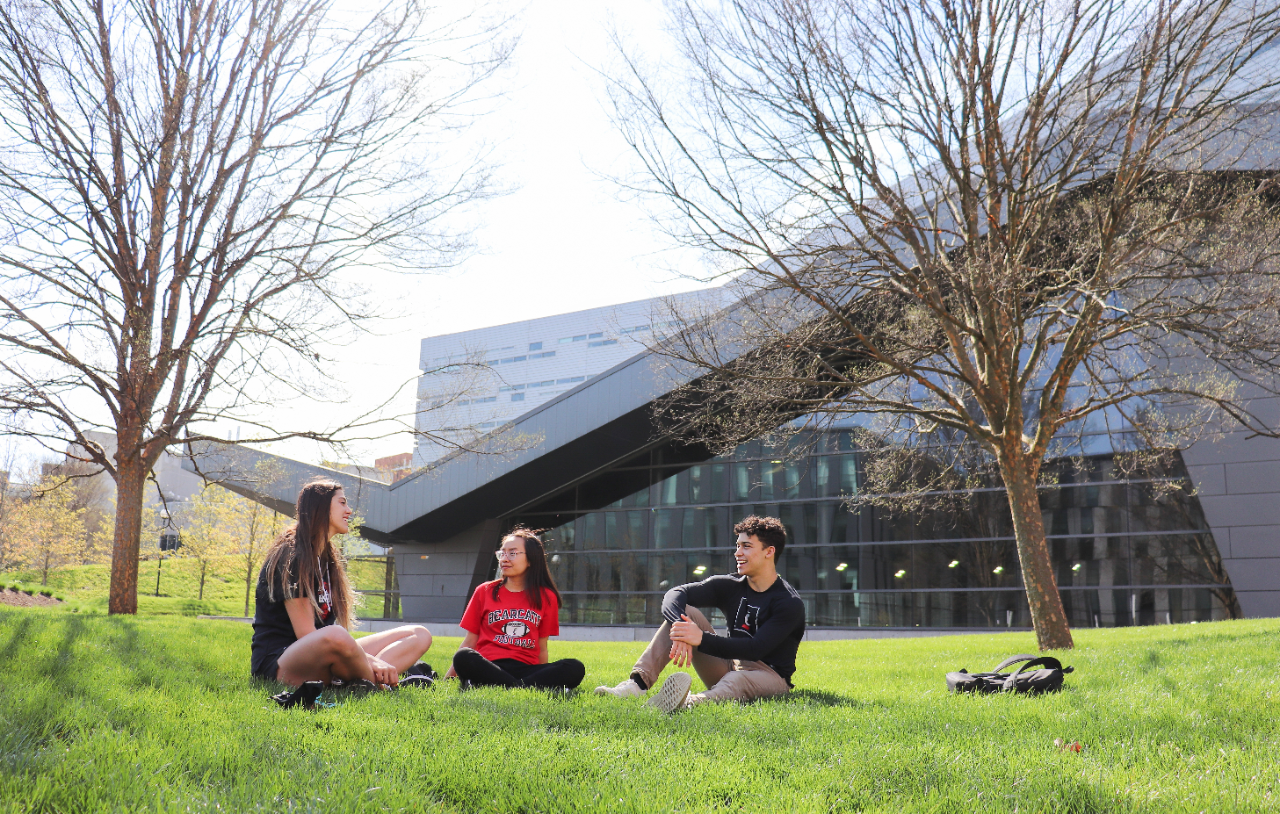 Students in grass by Recreation Center.